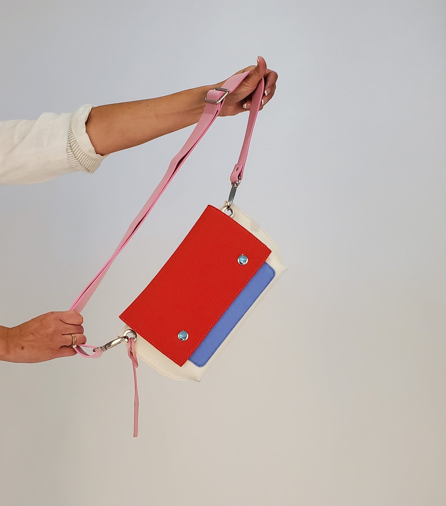 GREGOR Red Multi-Color Belt Bag: Compact and versatile, made from 3mm merino wool felt with vegan leather. Features two external pockets for large phones, one internal pocket, and a secure flap with magnetic buttons. Adjustable strap for various wear options. Handmade in Italy. Includes dust bag."