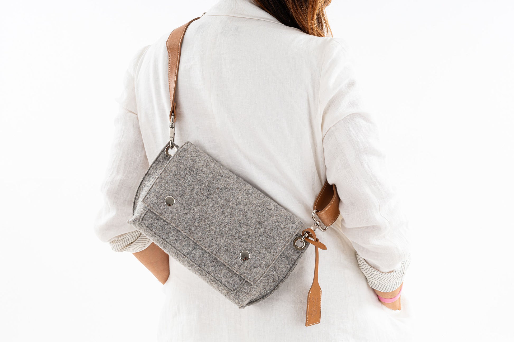 **Alt Text:**  "GREGOR Charcoal Grey Beltbag: Compact yet spacious, made from 3mm merino wool felt with a crossbody vegan leather strap. Features two external pockets for large phones, a smaller internal pocket, and a secure flap with magnetic buttons. Adjustable strap for versatile wear. Handmade in Italy. Includes dust bag."