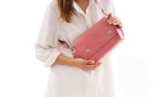GREGOR Pink Beltbag: Light and compact with surprising space, made from 3mm merino wool felt and vegan leather. Features two external pockets for large phones, a small internal pocket, and a secure flap with magnetic buttons. Versatile adjustable strap for various wear options. Handmade in Italy. Includes dust bag. - Lefrac