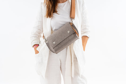 GREGOR Taupe Beltbag: A light, compact, and spacious belt bag made from 3mm Merino wool felt and vegan leather. Features include two external pockets for large phones, a smaller internal pocket for essentials, a flap with magnetic closure, and an adjustable strap. Ideal for daily use and versatile wear options. Handmade in Italy.