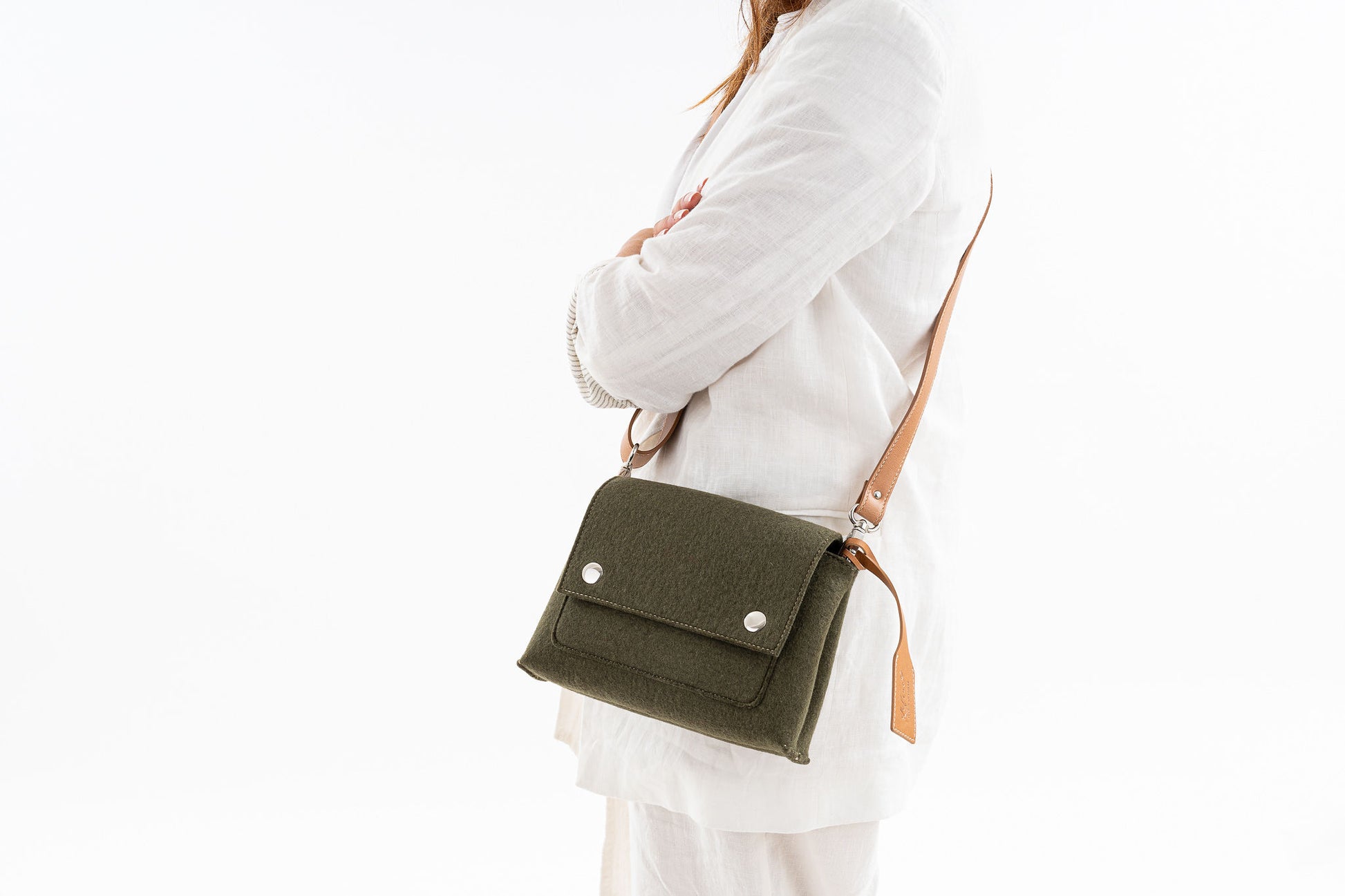 JOY Moss Green Crossbody Bag: Small, ergonomic, and stylish with three pockets (2 external, 1 internal) for essentials. Features an adjustable vegan leather strap, flap closure with magnetic buttons, and a versatile design for comfort and convenience. Ideal for daily errands.