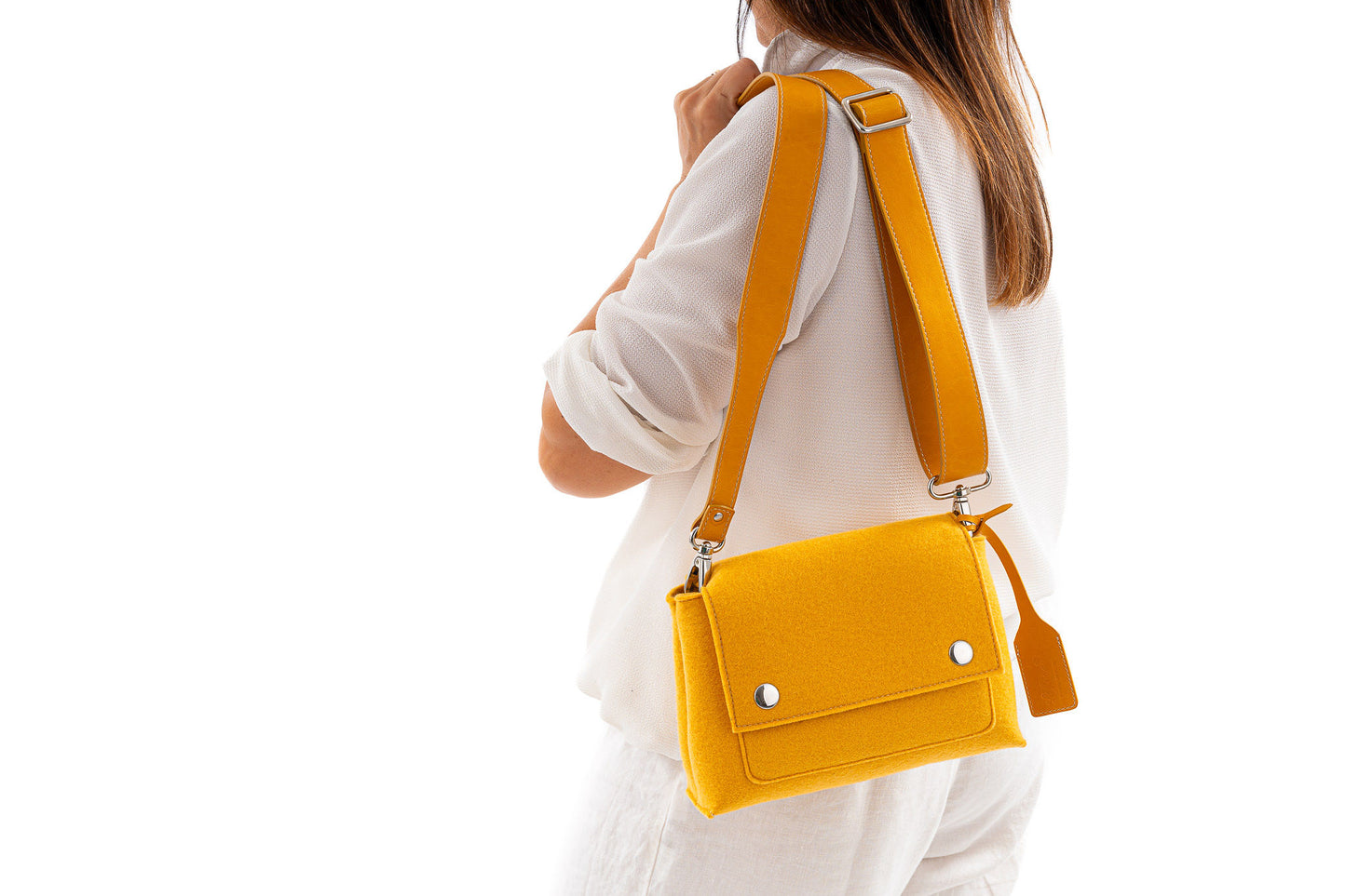 JOY Yellow Crossbody Bag: Small, stylish, and ergonomic with vibrant color options. Features 3 pockets (2 external, 1 internal) for essentials, flap with magnetic closure, and adjustable strap for comfort. Made from 3mm Merino wool felt and bio-based vegan leather. Handmade in Italy.