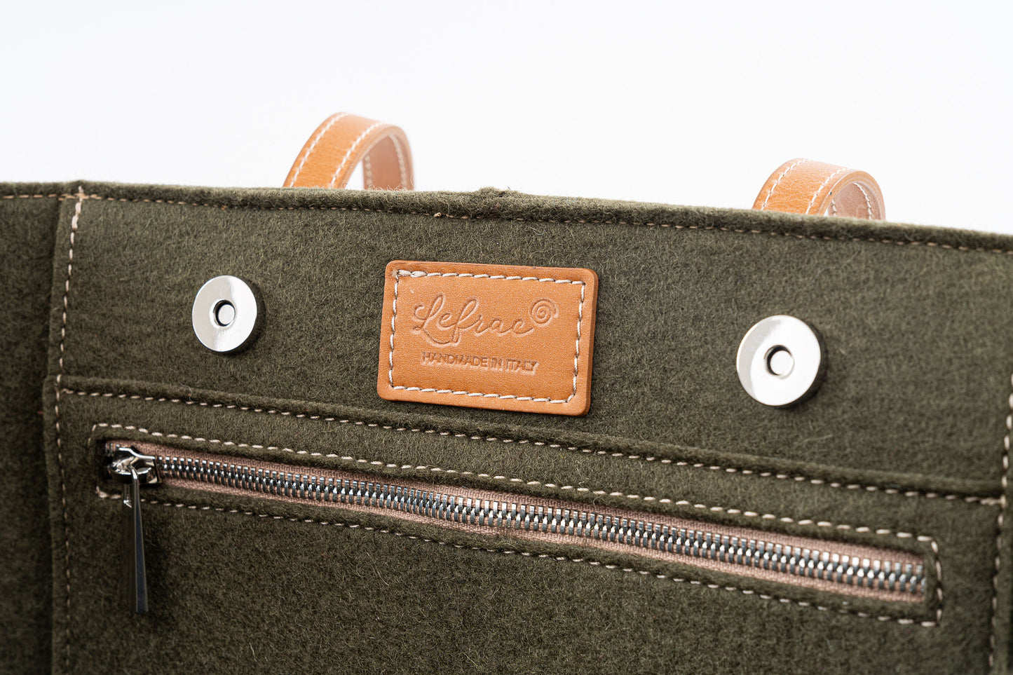Tote Bag Large Moss Green made of 3mm Merino wool felt and vegan leather. Features two internal pockets (one zippered, one open), magnetic closure, and a 27 cm handle drop. Fits laptops up to 13” and tablets. Comes with a cotton dust bag. Handmade in Italy with Lefrac logo pendant. - Lefrac