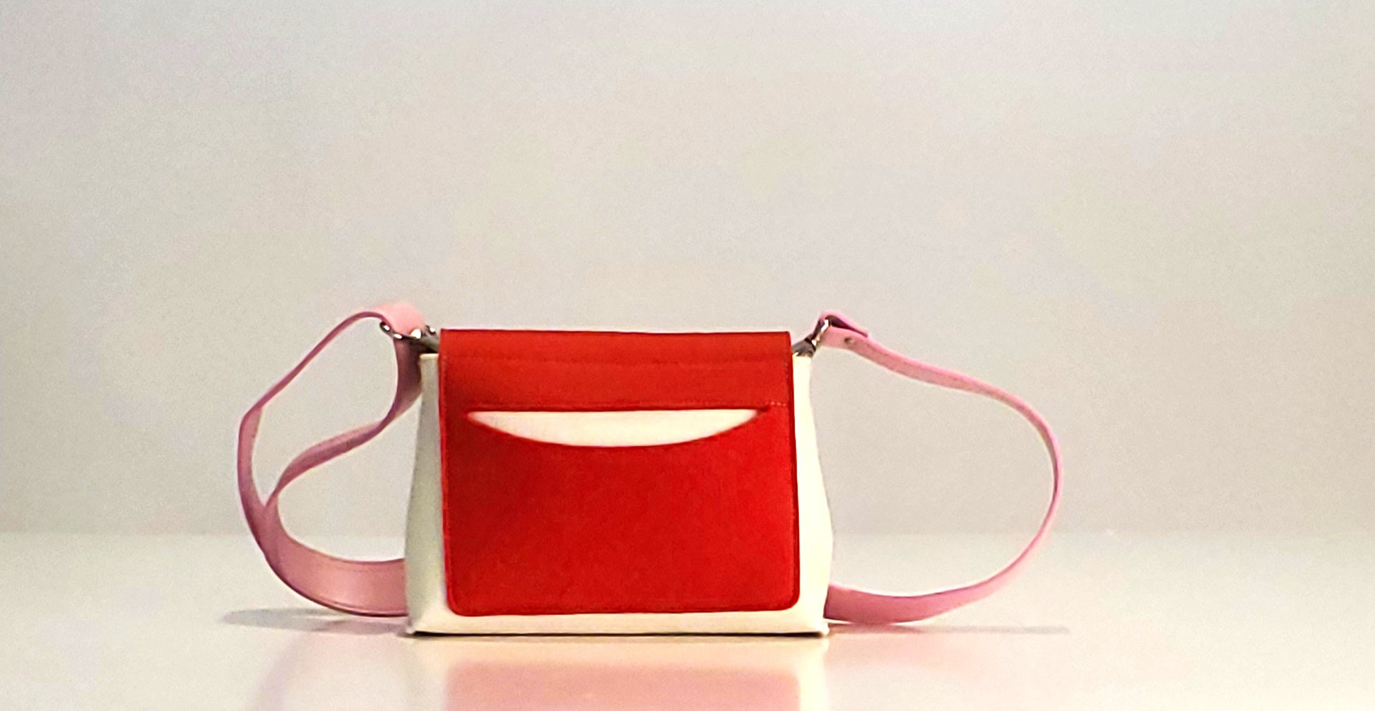JOY Red Multi-Color Crossbody Bag: Small, ergonomic, and vibrant with adjustable strap. Made from 3mm Merino wool felt and eco-friendly vegan leather. Features three pockets for organization—back pocket for phone, front, and internal pockets for keys and documents. Flap closure with magnetic buttons. Handmade in Italy. - Lefrac