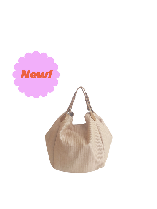Beige Margot bag: large, soft, and lightweight, crafted from cotton with a raffia-like texture. Features vintage-style vegan leather handles, 3 large pockets (one zippered), internal magnetic button, and a leather lace with carabiner for adjustable shape. Measures 36cm H x 36-56cm W x 25cm D. Comes with a dust bag and tracking. Vegan leather is 69% organic materials.- Lefrac
